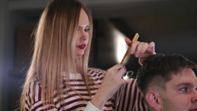Binnenland van het werk proces in moderne herenkapper wordt geschoten die Zijaanzichtportret van de aantrekkelijke jonge mens die stock footage Binnenland van het werk proces in moderne herenkapper wordt geschoten die Zijaanzichtportret van de aantrekkelijke jonge mens die stock footage