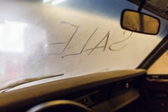 Binnenmening van oud gebroken autobinnenland met stoffig voertuigdashboard, achterspiegel, drijfstuurwiel en vuile wind royalty-vrije stock foto Binnenmening van oud gebroken autobinnenland met stoffig voertuigdashboard, achterspiegel, drijfstuurwiel en vuile wind royalty-vrije stock foto