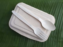 bioplastic δίκρανο κουταλιών και μίας χρήσης καλαθάκι με φαγητό στο φύλλο μπανανών Στοκ εικόνες με δικαίωμα ελεύθερης χρήσης bioplastic δίκρανο κουταλιών και μίας χρήσης καλαθάκι με φαγητό στο φύλλο μπανανών Στοκ εικόνες με δικαίωμα ελεύθερης χρήσης