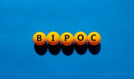 BIPOC symbol. Abbreviation BIPOC, black, indigenous and people of color on tennis balls. Beautiful blue background. Copy space.