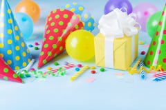 Birthday party background with gift or present box, colorful balloons, confetti, carnival cap and streamer. Holiday supplies