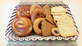 Biscoitos, bagels, rolos em uma cesta na tabela foto de stock Biscoitos, bagels, rolos em uma cesta na tabela foto de stock
