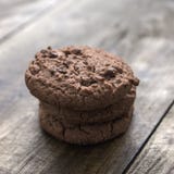 Biscotti di pepita di cioccolato su fondo di legno Immagini Stock Libere da Diritti Biscotti di pepita di cioccolato su fondo di legno Immagini Stock Libere da Diritti