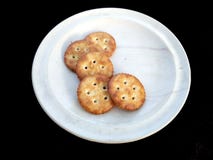 Biscuits dans le plat blanc d'isolement sur le fond noir photos stock Biscuits dans le plat blanc d'isolement sur le fond noir photos stock