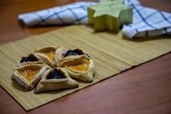 Biscuits de confiture de myrtille et d'abricot de Hamantash Purim avec la bougie en bois de forme de fond de table et d'?toile de photographie stock Biscuits de confiture de myrtille et d'abricot de Hamantash Purim avec la bougie en bois de forme de fond de table et d'?toile de photographie stock