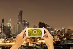 Bitcoin do ouro no telefone esperto da tela com construção em Banguecoque foto de stock royalty free Bitcoin do ouro no telefone esperto da tela com construção em Banguecoque foto de stock royalty free