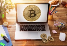 Bitcoin guld- mynt med bärbara datorn på träkontorstabellen arkivbilder Bitcoin guld- mynt med bärbara datorn på träkontorstabellen arkivbilder