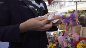 Biznesmen pozycja przy kwiatu bukieta sklepem i odliczającym pieniądze w jego portflu zdjęcie wideo Biznesmen pozycja przy kwiatu bukieta sklepem i odliczającym pieniądze w jego portflu zdjęcie wideo