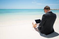 Biznesmen używa komputer na plaży obraz stock Biznesmen używa komputer na plaży obraz stock