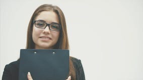 Biznesowi dama stojaki na białym tle W tym samym czasie trzyma czarną falcówkę z dokumentami obejmuje ona zbiory Biznesowi dama stojaki na białym tle W tym samym czasie trzyma czarną falcówkę z dokumentami obejmuje ona zbiory