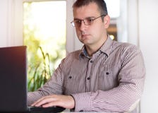 Biznesowy mężczyzna pracuje przy biurem z laptopem obraz stock Biznesowy mężczyzna pracuje przy biurem z laptopem obraz stock