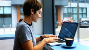 Bizneswoman ma filiżanki od kawę podczas gdy używać laptop zbiory Bizneswoman ma filiżanki od kawę podczas gdy używać laptop zbiory