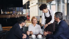Bizneswoman płaci dla lunchu z smartphone podczas spotkania z partnerami zbiory wideo Bizneswoman płaci dla lunchu z smartphone podczas spotkania z partnerami zbiory wideo