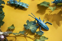 Black Beetle Decor on Yellow Surface With Green Leaves Stock Photos Black Beetle Decor on Yellow Surface With Green Leaves Stock Photos