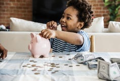 Black boy collecting money to piggy bank Stock Photo Black boy collecting money to piggy bank Stock Photo