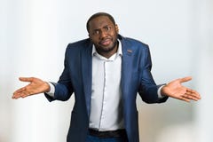 Free Black Businessman Shrugging Shoulders. Stock Image - 100057061
