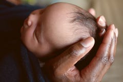 Black father holding newborn baby