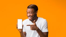 Black Man Showing Phone Blank Screen Standing, Orange Background, Mockup Royalty Free Stock Images Black Man Showing Phone Blank Screen Standing, Orange Background, Mockup Royalty Free Stock Images
