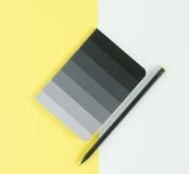 Black notepad and pensil on yellow background. Working place. Space for notes. Top view. Royalty Free Stock Photos Black notepad and pensil on yellow background. Working place. Space for notes. Top view. Royalty Free Stock Photos