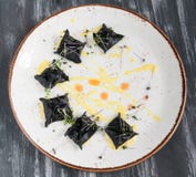 Black ravioli with seafood. On a plate top view. On wooden black background. royalty free stock photo Black ravioli with seafood. On a plate top view. On wooden black background. royalty free stock photo