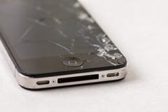 Black smartphone with crashed lcd touch screen above white marble background stock image Black smartphone with crashed lcd touch screen above white marble background stock image