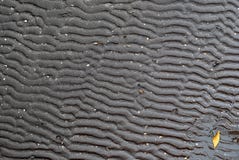 Black wet beach sand form in curve-line pattern with one orange stock photo Black wet beach sand form in curve-line pattern with one orange stock photo