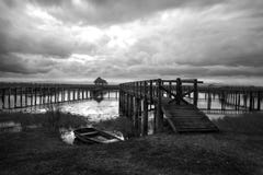 Black and white high contast lake with wooden bridge and boat in Stock Photography Black and white high contast lake with wooden bridge and boat in Stock Photography