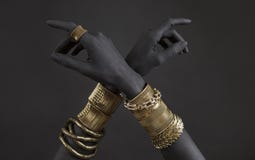 Black Woman`s Hands With Gold Jewelry. Oriental Bracelets On A Black Painted Hand Royalty Free Stock Photography