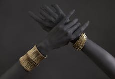 Black Woman`s Hands With Gold Jewelry. Oriental Bracelets On A Black Painted Hand Royalty Free Stock Photo