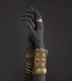 Black Woman`s Hands With Gold Jewelry. Oriental Bracelets On A Black Painted Hand Royalty Free Stock Image