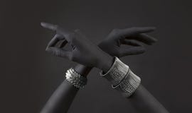 Black Woman`s Hands With Many Different Silver Jewelry. Oriental Bracelets On A Black Hand Stock Photo