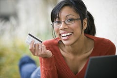 Black woman using credit card and laptop
