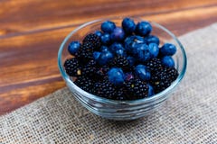 Blackberry and bog whortleberry in small glass bowl stock images Blackberry and bog whortleberry in small glass bowl stock images