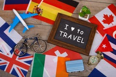 blackboard with text & x22;I love to Travel& x22;, flags of different countries, airplane model, little bicycle and suitcase