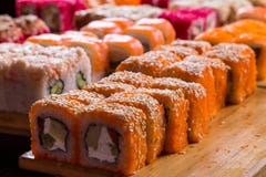 Blandad sushi och rullar på det wood brädet i mörkt ljus Arkivfoton Blandad sushi och rullar på det wood brädet i mörkt ljus Arkivfoton