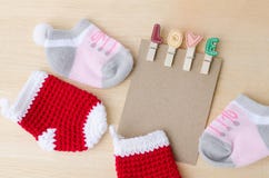 Blank paper note with love clips and baby socks on wooden backgr Stock Image Blank paper note with love clips and baby socks on wooden backgr Stock Image