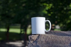 A blank white coffee mug on the stone edge stock photos A blank white coffee mug on the stone edge stock photos