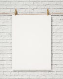 Blank white hanging poster with clothespin and rope on brick wall, background stock image Blank white hanging poster with clothespin and rope on brick wall, background stock image