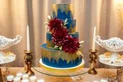 Blauwe die huwelijkscake door zich bloemen wordt verfraaid van feestelijke lijst met woestijnen te bevinden, aardbeitartlet en cu royalty-vrije stock foto Blauwe die huwelijkscake door zich bloemen wordt verfraaid van feestelijke lijst met woestijnen te bevinden, aardbeitartlet en cu royalty-vrije stock foto