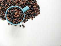 Blauwe koffiekop met koffiebonen die, met lege ruimte voor reclame omringen Hoogste mening stock afbeeldingen Blauwe koffiekop met koffiebonen die, met lege ruimte voor reclame omringen Hoogste mening stock afbeeldingen