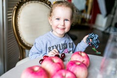 Blauäugiges nettes Mädchen, das an einem Tisch mit Äpfeln, Kirschen, Trauben und dem Lächeln sitzt lizenzfreie stockfotos Blauäugiges nettes Mädchen, das an einem Tisch mit Äpfeln, Kirschen, Trauben und dem Lächeln sitzt lizenzfreie stockfotos