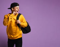 Blije jonge die mensenstudent met een rugzaklooppas in studio op een purpere achtergrond wordt ge?soleerd stock afbeeldingen Blije jonge die mensenstudent met een rugzaklooppas in studio op een purpere achtergrond wordt ge?soleerd stock afbeeldingen