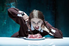 Blodigt allhelgonaaftontema: galen flicka med en kniv, en gaffel och ett kött arkivbilder Blodigt allhelgonaaftontema: galen flicka med en kniv, en gaffel och ett kött arkivbilder
