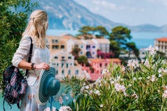 Blond beautiful woman enjoying view of colorful tranquil village Assos on sunny summer travel vacation day. Visiting stock image Blond beautiful woman enjoying view of colorful tranquil village Assos on sunny summer travel vacation day. Visiting stock image