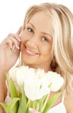 Blond gai avec les tulipes et le téléphone blancs photo libre de droits Blond gai avec les tulipes et le téléphone blancs photo libre de droits