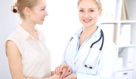 Blond kvinnlig doktor och patient som talar i sjukhuskontor Hälsovård och klientservice i medicin arkivbilder Blond kvinnlig doktor och patient som talar i sjukhuskontor Hälsovård och klientservice i medicin arkivbilder