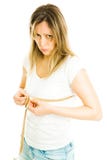 Blond slim woman in white shirt and jeans measure chest size with tape meter - not happy stock photo Blond slim woman in white shirt and jeans measure chest size with tape meter - not happy stock photo