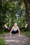 Blond ung kvinna som gör eldflugayogaställing arkivfoto Blond ung kvinna som gör eldflugayogaställing arkivfoto