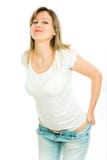 Blonde Frau im wei?en T-Shirt, das versucht, ihre festen Jeans zu kleiden lizenzfreies stockfoto Blonde Frau im wei?en T-Shirt, das versucht, ihre festen Jeans zu kleiden lizenzfreies stockfoto