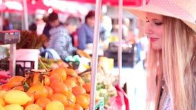 Blonde girl at the market, smelling fruit